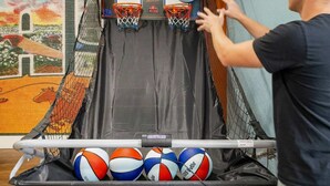 A basketball hoop with two basketballs and a net. - Pool Games Pickleball Putt Putt Fun (San Antonio)
