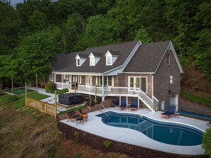 A two-story house with a covered patio and a swimming pool. - Massive Asheville Compound A Memorable Experience (Weaverville)