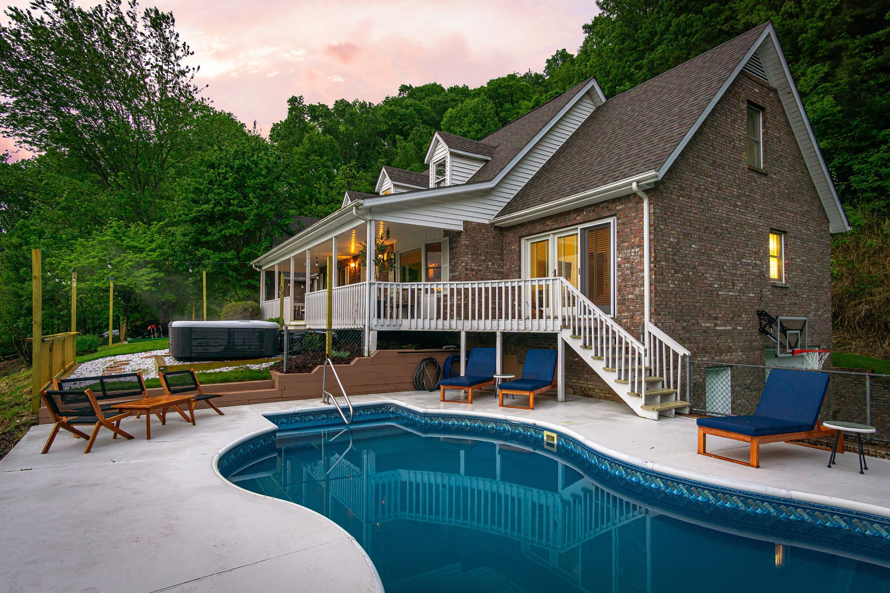 Ein Haus mit Swimmingpool, Sitzgelegenheit im Freien und einer Terrasse.