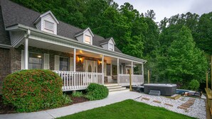 Une maison à deux étages dotée d’un porche couvert, d’un jacuzzi et d’une pelouse bien entretenue.