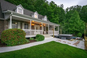 A two-story house with a covered porch, a hot tub, and a well-maintained lawn. - Massive Asheville Compound A Memorable Experience (Weaverville)