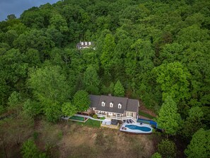 A two-story house with a swimming pool, surrounded by dense forest. - Massive Asheville Compound A Memorable Experience (Weaverville)