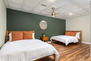 Une chambre d’hôtel avec deux lits, un plancher en bois et un plafond doté d’un éclairage encastré.