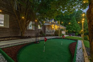 A miniature golf course with a house in the background. - Massive Asheville Compound A Memorable Experience (Weaverville)