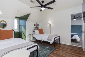 A bedroom with two beds, a ceiling fan, a wall-mounted lamp, and a door with colorful wall stickers. - Massive Asheville Compound A Memorable Experience (Weaverville)
