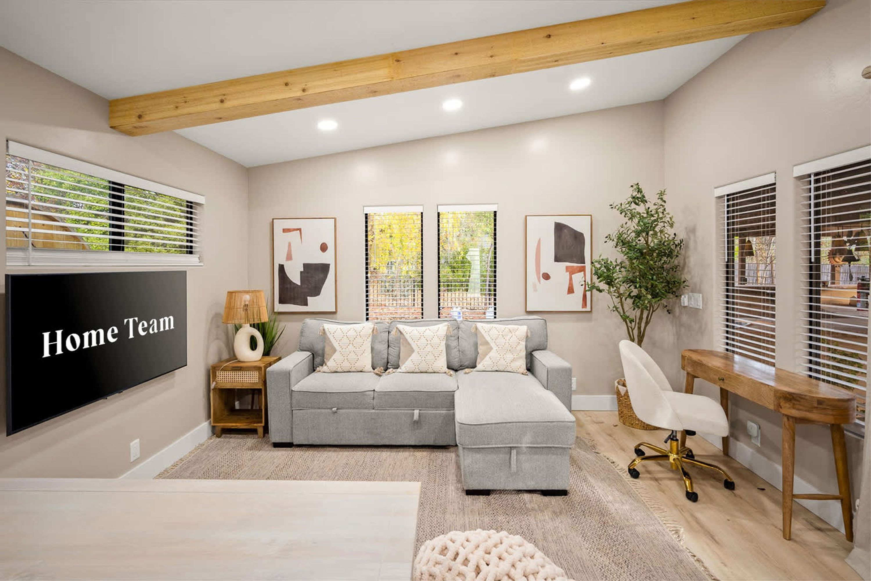 A modern living room with a sectional sofa, a TV, and artwork on the walls.