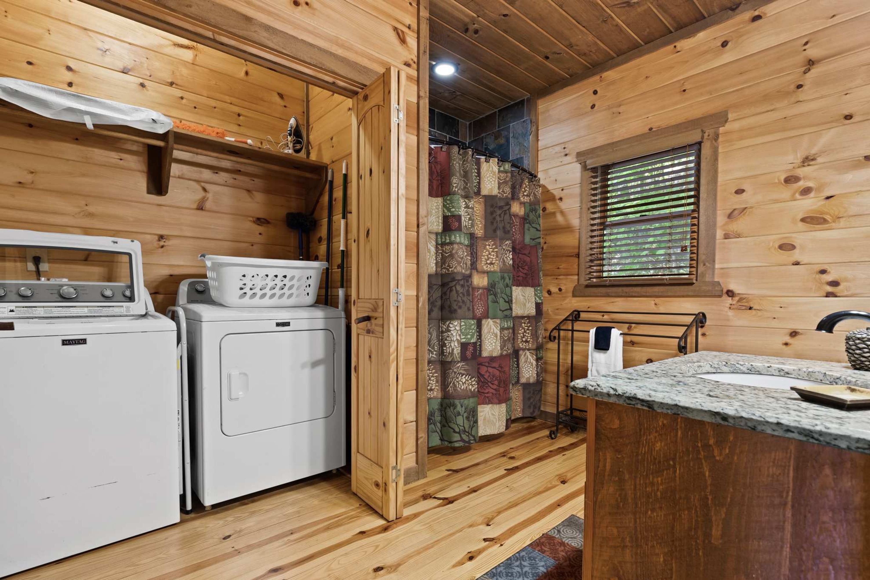 A compact kitchen with a washing machine, a dryer, and a small countertop with a sink.