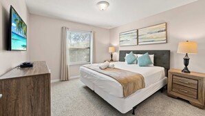 A hotel room with a bed, bedside tables, a desk, and a window with blinds. - Magic Moments Villa Private Pool Spa Games (Kissimmee)