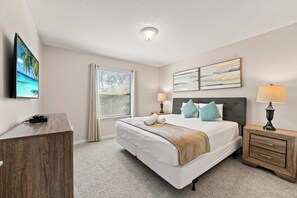 A hotel room with a bed, bedside tables, a desk, and a window with blinds. - Magic Moments Villa Private Pool Spa Games (Kissimmee)
