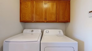 A laundry area with two white washing machines and wooden cabinets above. - Sleeps 10 Heated Pool Putt Putt Dogs Welcome (Chandler)