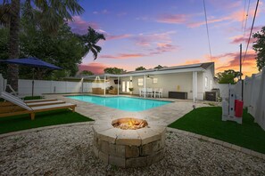 A backyard with a swimming pool, a fire pit, and outdoor furniture. - Coastin Close Family Fun HTD Pool Outdoor Games (Pinellas Park)