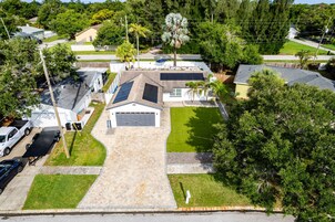 Propiedad residencial con garaje, paneles solares y césped bien cuidado.