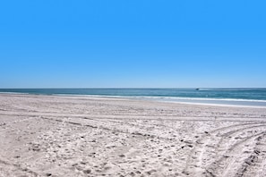 A beach with visible tire tracks and a clear blue sky. - Steps to the Beach Pool Courts Family Fun (Destin)