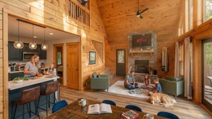 A wooden cabin interior with a kitchen, dining area, and living room. - The Summit in Mars Hill (Mars Hill)