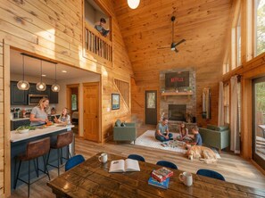 A wooden cabin interior with a kitchen, dining area, and living room. - The Summit in Mars Hill (Mars Hill)