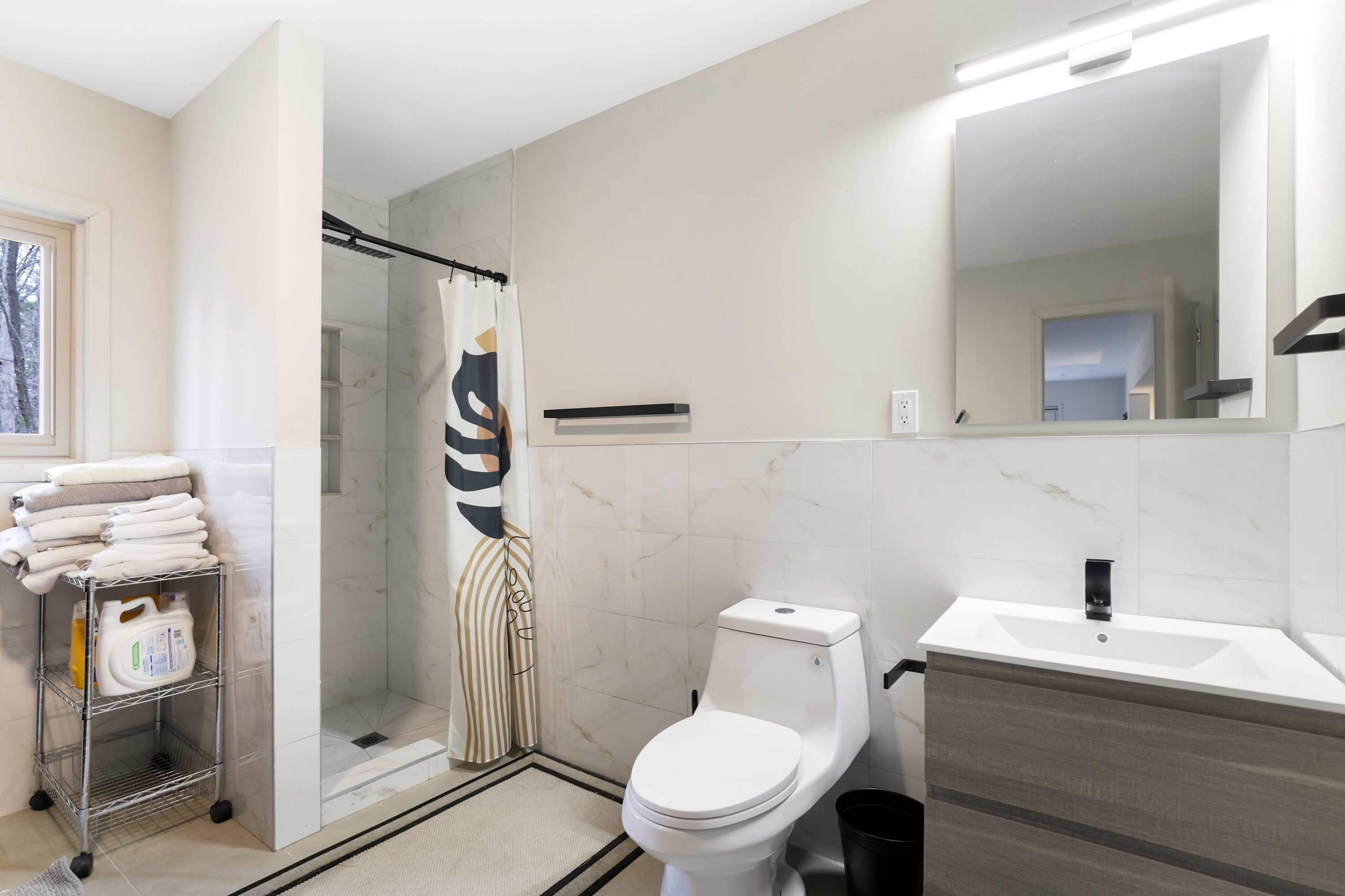 A bathroom with a shower, toilet, and sink.