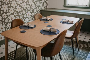 A dining table with four chairs, each with a napkin on a placemat. - Briarwood Cottage Hot Tub Putt Putt Games (Aiken)