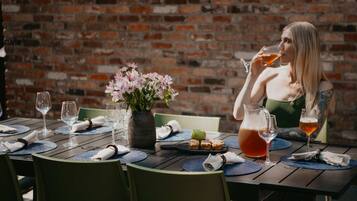 A dining table set with plates, glasses, and a pitcher of a beverage.