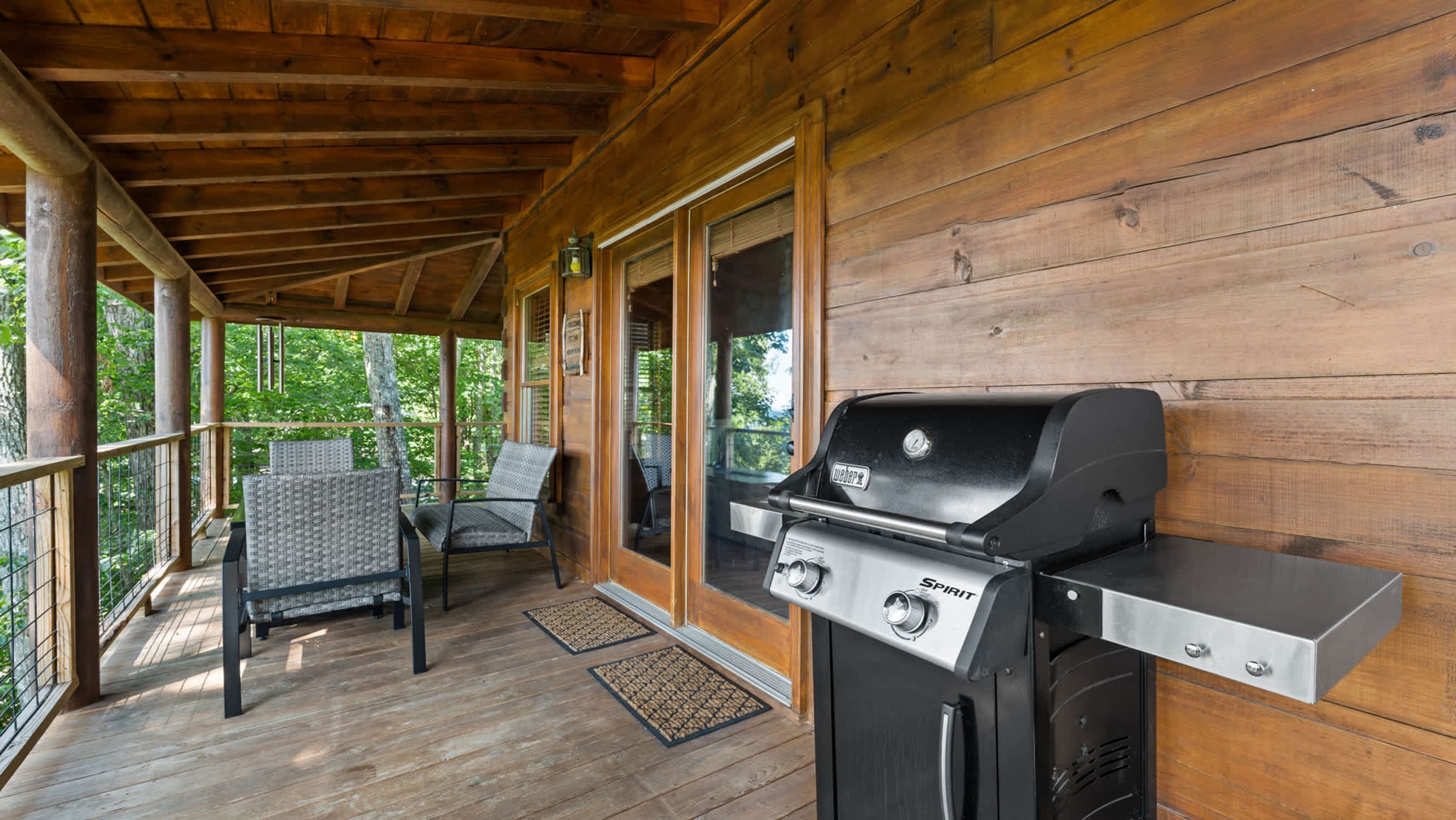 Un espace extérieur abrité, doté d’un barbecue, de sièges et de murs en bois.