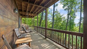 A wooden deck with a railing, a swing, and a table. - MTN Views Hot Tub Fire Pit Pool Table Games (Morganton)
