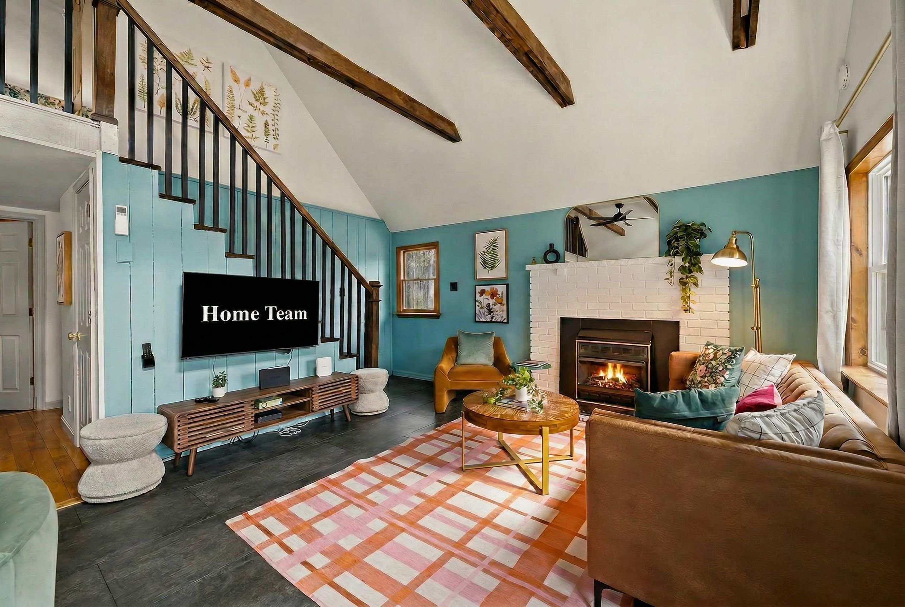 A living room with a fireplace, a television, and a staircase.