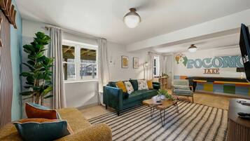 A modern living room with a sofa, a coffee table, and a dining area with a bar.