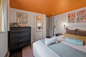 Un dormitorio con cama, cómoda y decoración en la pared.