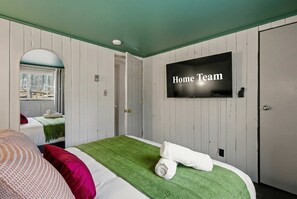 A hotel room with a bed, a television, and a door. - Pocono Retreat Spacious Deck Fire Pit Games (Pocono Lake)