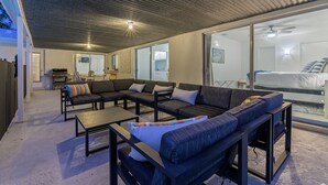 A modern living room with a sectional sofa, a coffee table, and a fireplace. - Breezy Blue-pool Hot Tub Minutes to Beach Games (Largo)