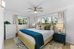 A bedroom with a bed, nightstands, a dresser, a ceiling fan, and windows with curtains. - Breezy Blue-pool Hot Tub Minutes to Beach Games (Largo)