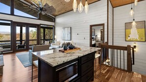A spacious kitchen with a large island, wooden flooring, and a ceiling fan. - 2-level Deck - Stunning Views - Hot Tub - Fire Pit (Ellijay)