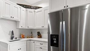 A modern kitchen with white cabinetry, a stainless steel refrigerator, and a built-in water dispenser. - 2-level Deck - Stunning Views - Hot Tub - Fire Pit (Ellijay)