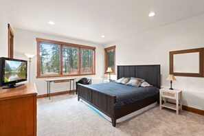 A bedroom with a bed, a desk, a television, and a window with a view of trees. - 34 Acre Escape Games Hiking Pool Table Bicycles (Black Hawk)