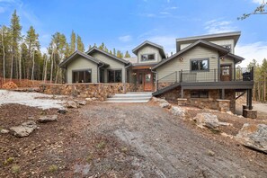 A two-story house with a stone foundation, a front porch, and a driveway leading to the entrance. - 34 Acre Escape Games Hiking Pool Table Bicycles (Black Hawk)