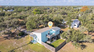 Une maison de plain-pied avec un toit plat, une petite terrasse et une cour clôturée.