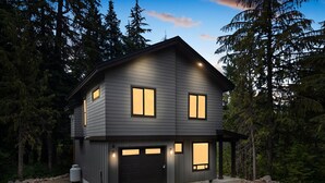 A two-story house with a garage, surrounded by trees. - 2 Homes Sleeps 22 Sauna Hot Tub Fire Pit (Government Camp)