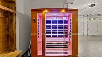 A sauna with a wooden exterior, a glass door, and a control panel on the wall.