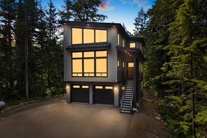 A modern two-story house with large windows, a covered porch, and a staircase leading to the upper level. - 2 Homes Sleeps 22 Sauna Hot Tub Fire Pit (Government Camp)