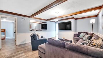 A living room with a sofa, a television, and a lamp.
