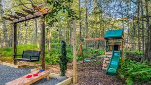 A playground with a swing set, slide, and bench. - Poconos Pines Escape Sauna Hot Tub Playground (Pocono Lake)