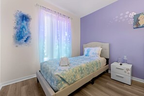 A bedroom with a bed, a nightstand, and a wall decoration. - 12 min to Disney Movie Theater Pool In-ground spa (Davenport)