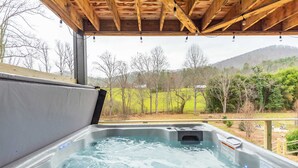 A hot tub with a wooden roof overhead, surrounded by a grassy landscape and trees. - Mountain Retreat Sauna Outdoor Dining Nature (Asheville)