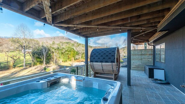A hot tub with a wooden deck and a view of a mountainous landscape. - Mountain Retreat Sauna Outdoor Dining Nature (Asheville)