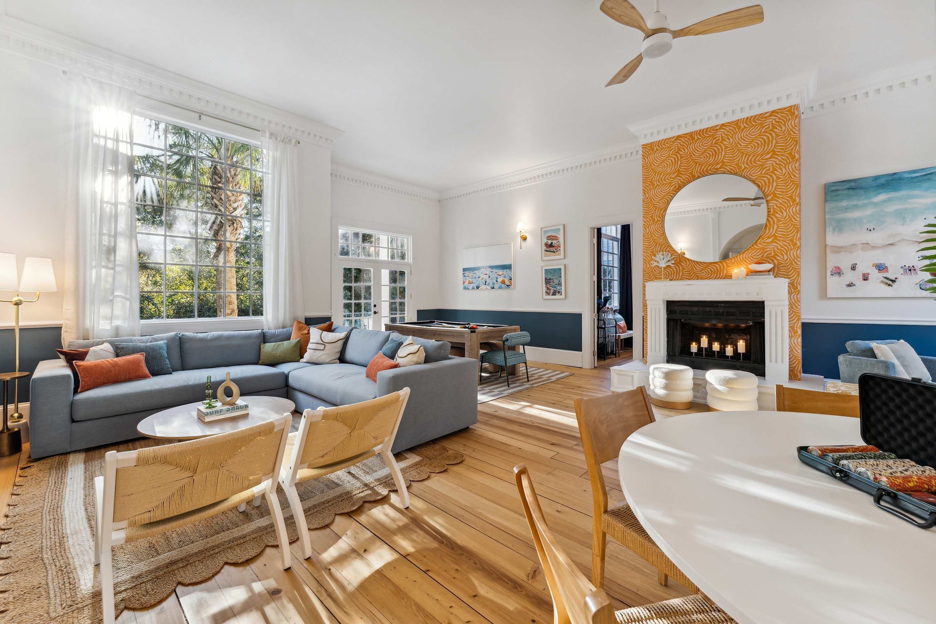 A spacious living room with a large sofa, a dining table, and a fireplace.