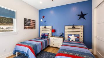 A bedroom with two beds, a nightstand, a globe, and a star decoration on the wall.