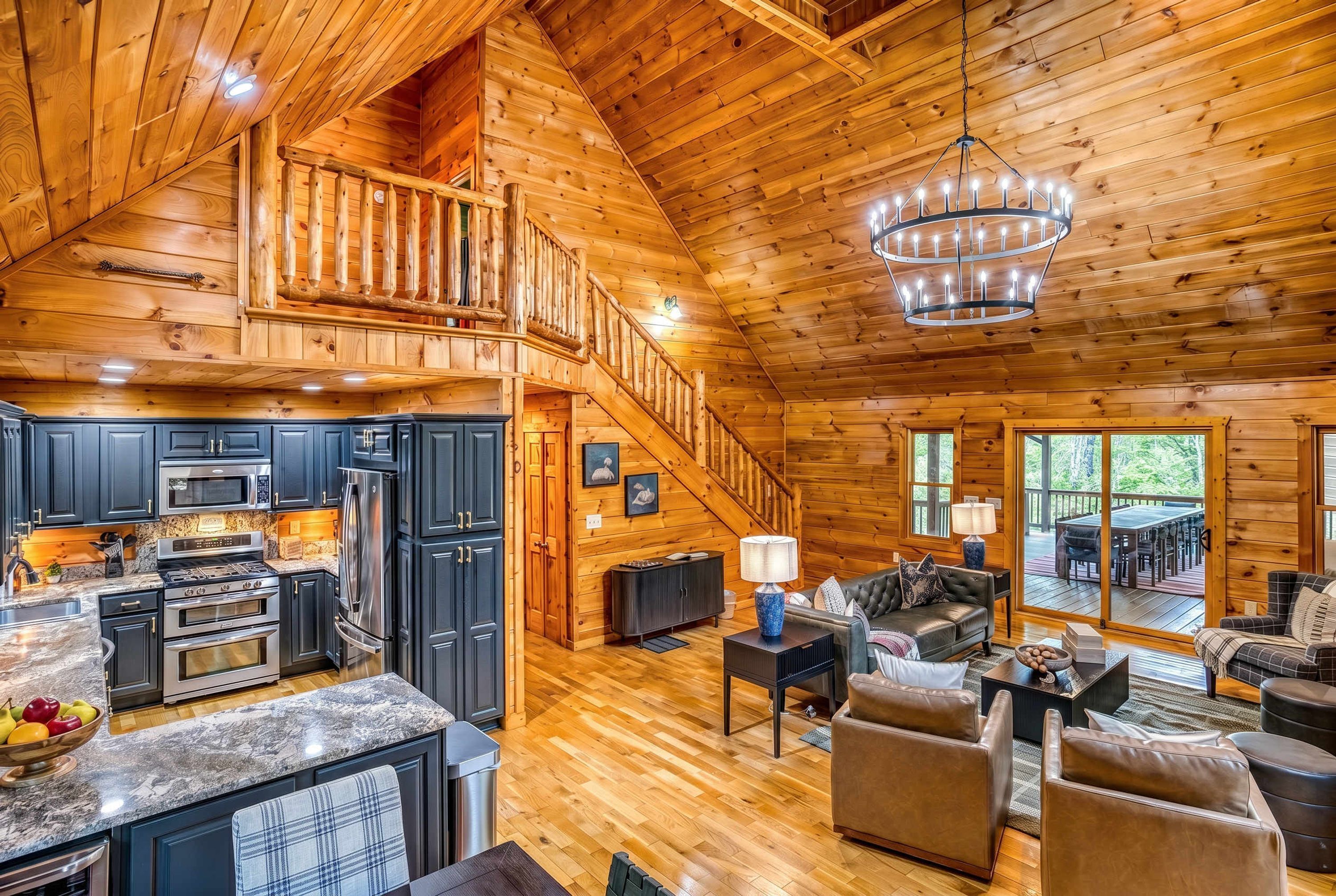 A spacious cabin with a kitchen, dining area, and a large living room with a fireplace.