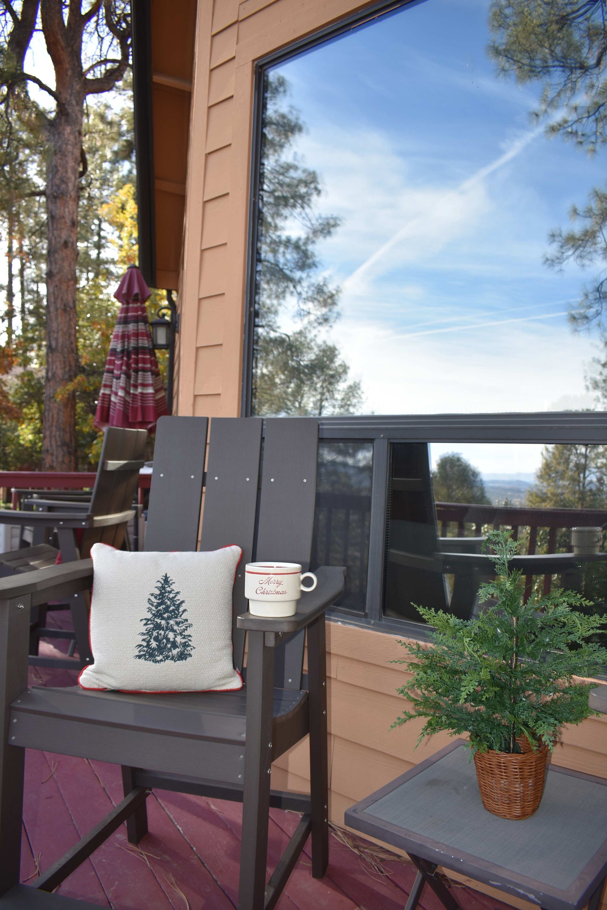 A deck with a chair, a small table, and a potted plant.