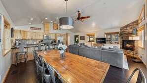 Una cocina amplia con armarios de madera, un comedor con mesa de madera y una sala de estar con chimenea.