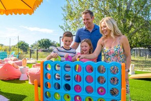 Eine Familie spielt ein Spiel mit bunten Ringen auf einem blauen Brett.