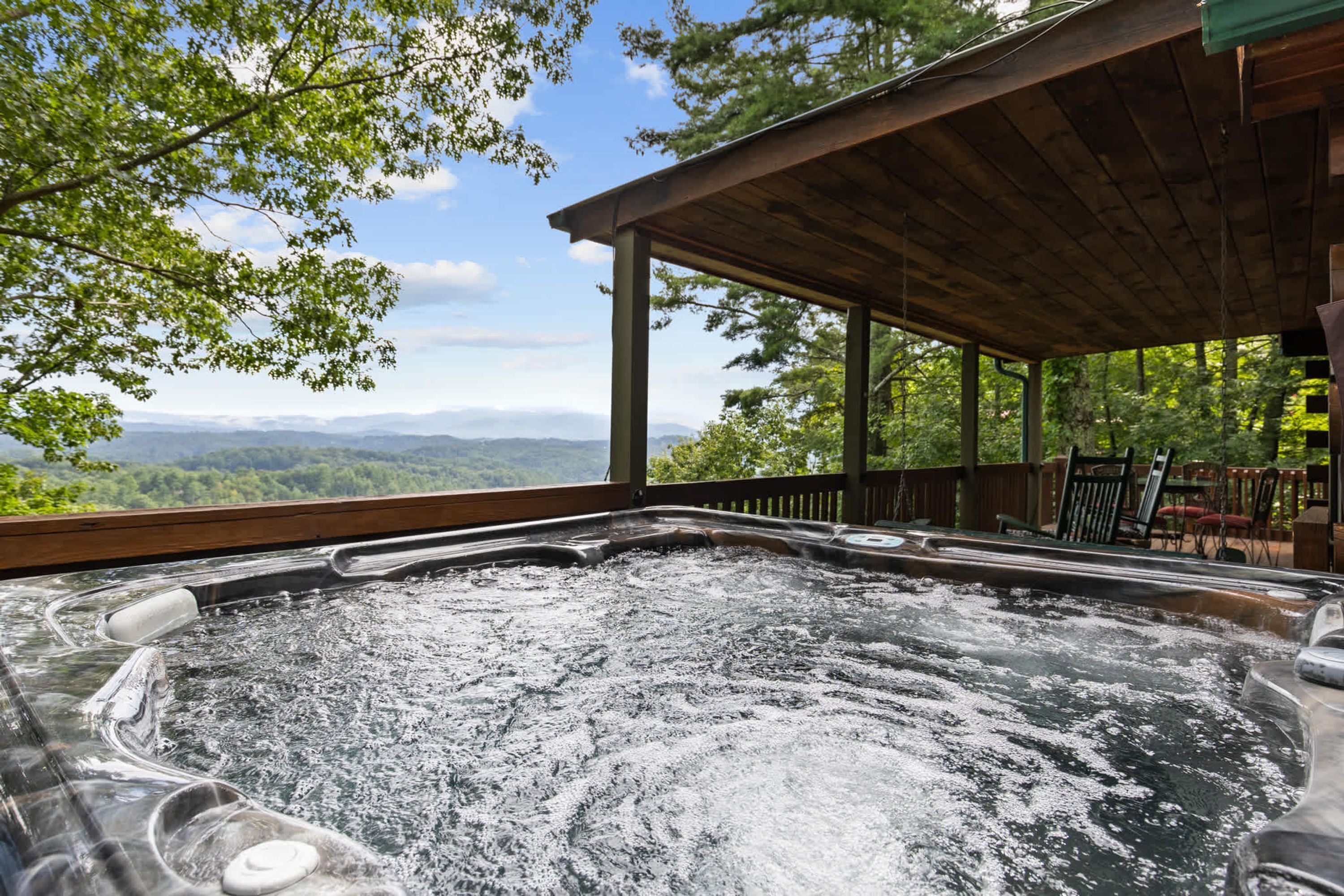 Un bain à remous avec vue sur les montagnes et les arbres.